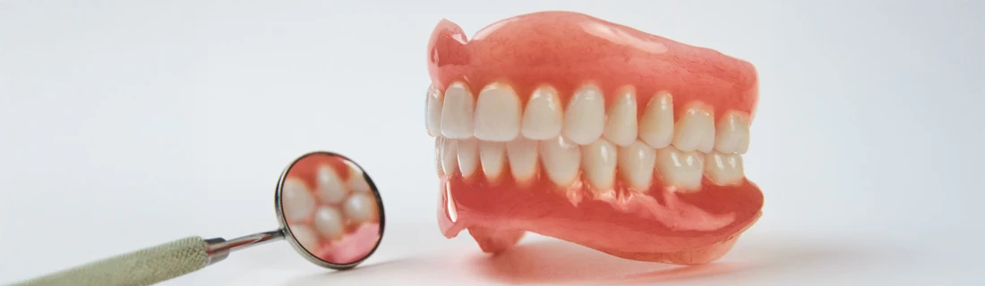 Dentist Lewiston ME Dentures close up photo of a pair of upper and lower dentures sitting on the table
