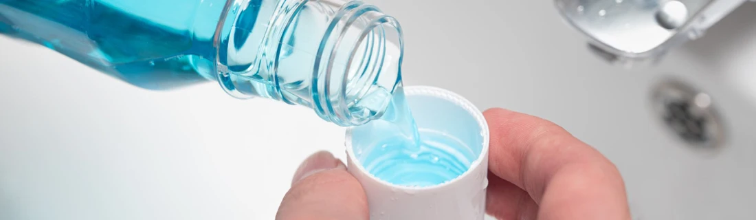 Dentist Lewiston ME Dry Mouth close-up of someone pouring a serving of mouthwash into the cap in the bathroom