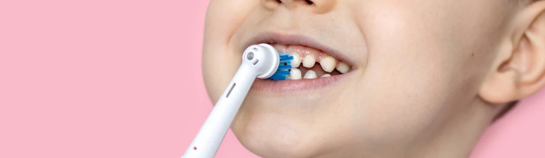 Dentist Lewiston ME Pediatric Dentistry close up of a young boy brushing his teeth with an electric toothbrush
